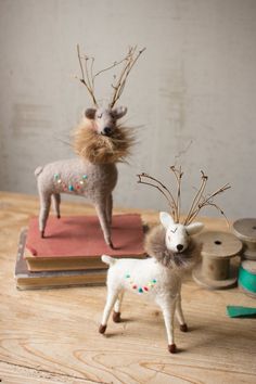 two deer figurines on top of books with sprinkles and needles