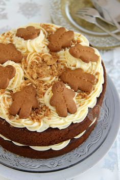 a chocolate cake with white frosting and brown teddy bears on top, sitting on a plate