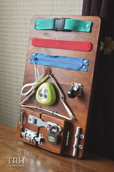 an assortment of items are displayed on a wooden board with zippers and cords attached to it