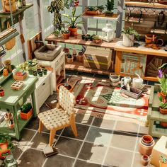 a room filled with lots of potted plants next to a table and chair on top of a tiled floor