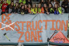 a group of young people standing behind a banner that says de construction zone on it