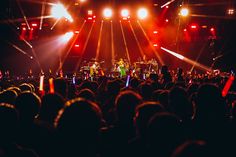 a group of people standing on top of a stage with lights in front of them