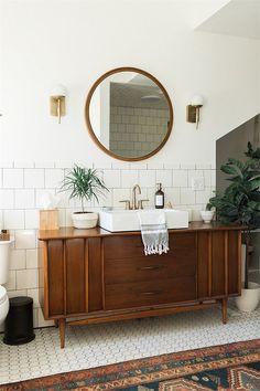 a bathroom with a sink, mirror and rug on the floor in front of it