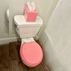 a white toilet with pink and silver polka dots on it