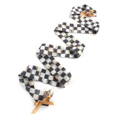 three pieces of black and white checkered paper tied to each other with wooden bows