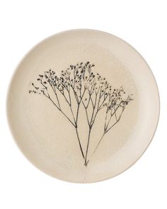 a white plate with some black flowers on the front and back of it, against a white background