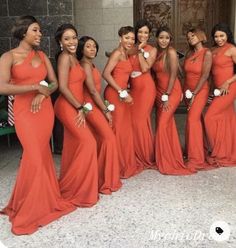 a group of women standing next to each other wearing red dresses and holding bouquets