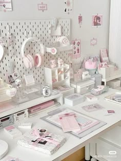 a desk with lots of pink and white items on it's sides, including books