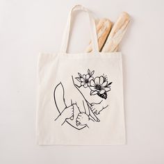 a tote bag with bread and flowers on it