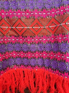 "Rad vintage 70's woven floral geometric poncho. Pink and purple tone laced with metallic gold. Red fringe. Large head hole, for an optional off-shoulder look. Feels like acrylic. Not the softest ever, or very warm. Eye caching and unique! Magical, even. Good vintage condition. Length: (excluding fringe) 16\" Fringe is 4\" Width across bottom: 48\" Head hole: 17\"" Red Bohemian Poncho For Festival, Red Shawl Poncho For Festival, Pink Shawl For Festival, Traditional Red Poncho For Festivals, Red Folk Style Poncho For Festival, Red Bohemian Shawl With Fringe, Red Bohemian Poncho With Fringe, Multicolor Woven Shawl For Festivals, Multicolor Shawl With Tassels For Festival