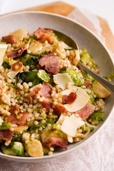 a bowl filled with salad and topped with bacon, lettuce, and other toppings