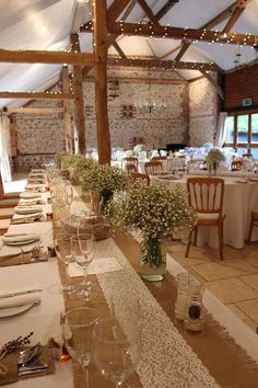 the tables are set with place settings and flowers in vases on top of them