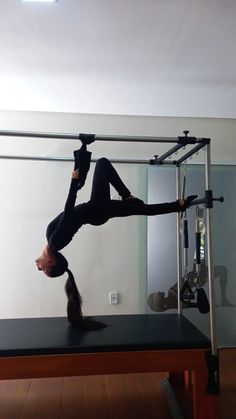 a woman doing a handstand on top of a table