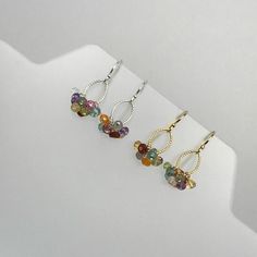 "Bring a little bit of joy and sparkle to any outfit with our Multicolor Gemstone Cluster earrings. Light and eye catching, we have added every color of the rainbow to these beauties. After all, why choose one color when you can have them all?! Each faceted bead is hand wrapped in either 14K Gold-Filled or Sterling Silver Wire and added to a delicate textured link and ear wire in coordinating materials. Light enough for every day yet bold enough to take center stage for special occasions. Stones Multicolor Earrings, Rainbow Earrings, Earrings Minimalist, Cluster Earrings, Delicate Earrings, Earrings Boho, Stylish Gifts, Center Stage, Earrings Dangle