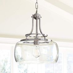 a glass light fixture hanging from a ceiling in a room with white walls and windows