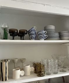 the shelves are filled with dishes and cups