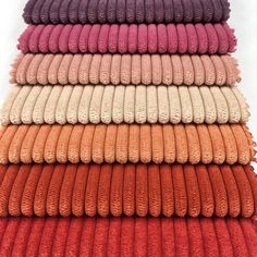 towels stacked on top of each other in different colors and sizes, all folded together