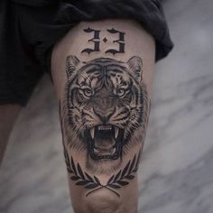 a man with a tiger tattoo on his leg and the word f is in front of him