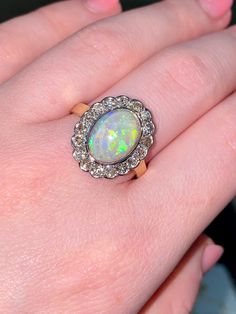 This 14carat yellow gold fire opal and diamond ring is truly breathtaking. With colour flashes of red, orange, yellow, and green, this is an opal lover's dream! The ring showcases an oval natural opal measuring 9.00 x 12.00 mm and weighing 5 carat.  It is surrounded by diamonds in a halo style setting that compliment the opal beautifully. The 17 round brilliant cut diamonds equaling 0.85 carat total weight just add to this stunning ring. Ring size - W (UK), 11 (USA) 🔹Sale Price - £1745.00 All a Victorian Luxury Gold Opal Ring, Victorian Yellow Gold Opal Cabochon Ring, Victorian Style Gold Opal Ring With Multi-stone, Gold Multi-stone Opal Ring With Oval Cabochon, Antique 14k Gold Opal Ring, Oval Cabochon, Opal And Diamond Ring, Fire Opal Ring, Halo Style, October Birthstone