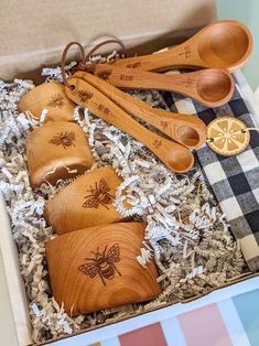 wooden spoons and measuring spoons are in a box with plaid tablecloth on the floor