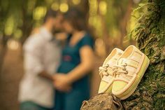 a pair of yellow shoes sitting on top of a tree trunk in the woods next to a couple