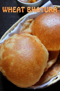 two buns sitting on top of each other in a basket next to some dipping sauce