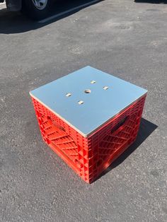 an orange box sitting in the middle of a parking lot