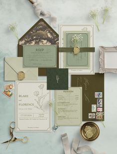 an assortment of wedding stationery items are laid out on a table with scissors and ribbons