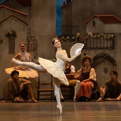 a ballerina is performing in front of other dancers