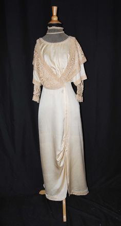 "EDWARDIAN IVORY SATIN CHARMEUSE WEDDING GOWN  WITH TAPE LACE ON NET, 1915-1918 This is an attractive Edwardian ivory colored satin charmeuse wedding gown dating from 1915-1918 time period. Thiss is a gown that a  mid to upper class dress that a woman would wear. The bodice is decorated with a tape lace on net with machine lace edging,  on front and back drop. With a high neck collar with stays is decorated with faux pearls and white beads.  Both shoulder collar and front and inner sleeves and b Vintage Floor-length Wedding Dress, Cream Vintage Dress For Wedding, Vintage Victorian Dress With Empire Waist For Formal Occasions, Elegant Vintage Wedding Dress With Historical Design, Regency Style Vintage Wedding Dress With Historical Design, Vintage Beige Dress For Wedding Night, Cream Floor-length Vintage Dress For Wedding, Vintage Evening Gown With Historical Design, Victorian Wedding Dress With Historical Design