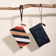 two small purses hanging from a tree branch