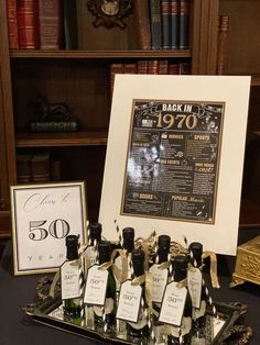 bottles of liquor are sitting on a tray in front of a chalkboard with an old - fashioned sign