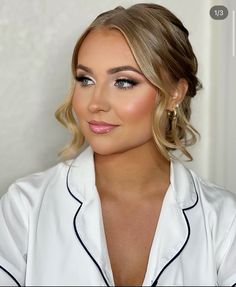 a woman with blonde hair and blue eyes wearing a white shirt is looking at the camera