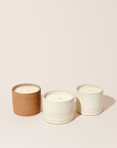 two white candles sitting next to each other