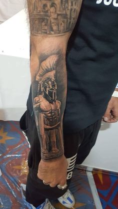 a man with a black and grey tattoo on his arm