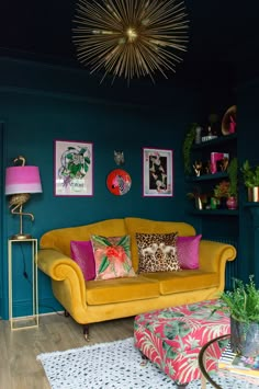 a living room with blue walls and yellow couches in the corner, colorful pillows on the floor