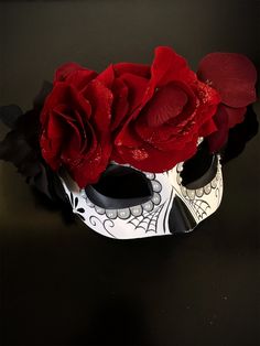 a white mask with red roses on it