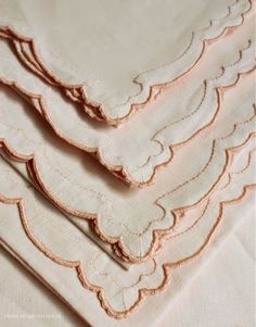 four pieces of cloth with scalloped edges