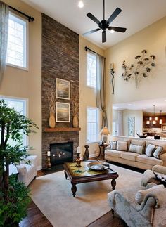 a living room filled with furniture and a fire place in the middle of a room