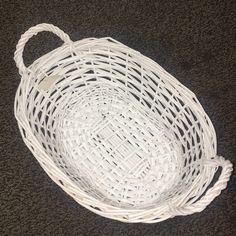 a white wicker basket sitting on the floor