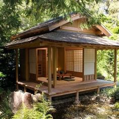 a small wooden building sitting in the middle of a forest