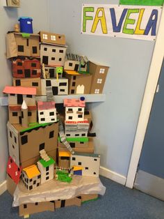 cardboard boxes stacked on top of each other in front of a wall with a sign that says favela