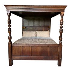 a wooden bed frame with four posts and pillows on the headboard, against a white background