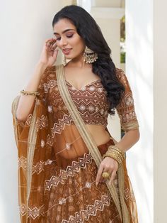 Indulge in the timeless elegance of this enchanting brown butterfly net lehenga adorned with intricate details of cotton threadwork, sequins, and embroidered motifs. The rich, earthy hue adds a touch of sophistication to your ensemble, while the delicate craftsmanship enhances its allure.
The semi-stitched lehenga boasts a generous 3-meter flair, ensuring graceful movement with every step, and can be customized up to 42 inches to perfectly complement your silhouette. Paired with an unstitched ch Bollywood Style Lace Choli For Reception, Festive Floor-length Lace Choli, Semi-stitched Lace Bollywood Choli, Brown Anarkali Set With Dupatta For Festive Occasions, Traditional Lace Choli With Sheer Dupatta, Brown Dupatta With Intricate Embroidery, Festive Brown Anarkali Set With Dupatta, Fitted Lace Lehenga For Festivals, Traditional Net Choli For Reception