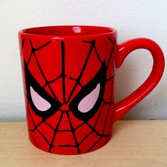 a red mug with a spiderman face on it