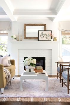 a living room filled with furniture and a fire place in front of a white fireplace