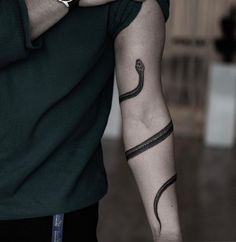 a man with a snake tattoo on his arm