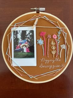 an embroidery hoop with flowers and a photo on it