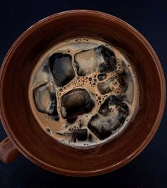 a cup filled with liquid and ice on top of a table