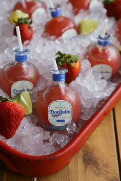 strawberry margaritas and limeade on ice in a red tray with strawberries for garnish